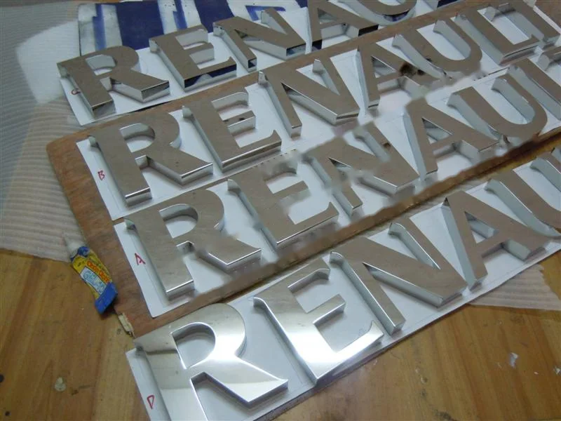 Metal sign letters on the workshop bench before finishing