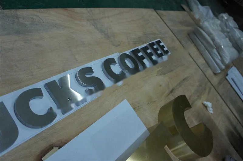 Metal sign letters on the workshop bench before finishing