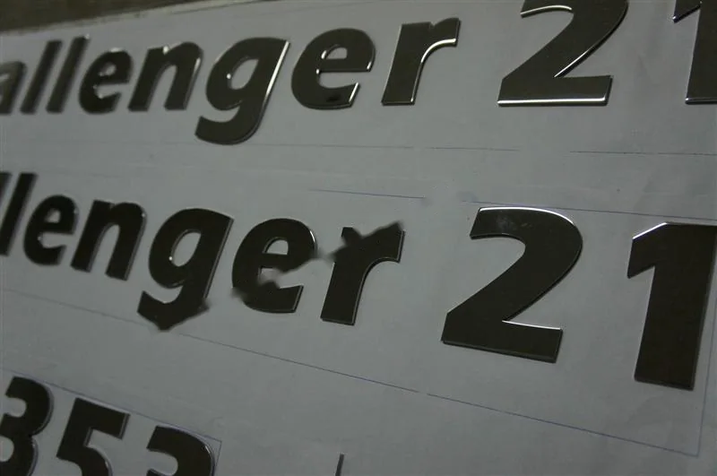 Metal sign letters on the workshop bench before finishing