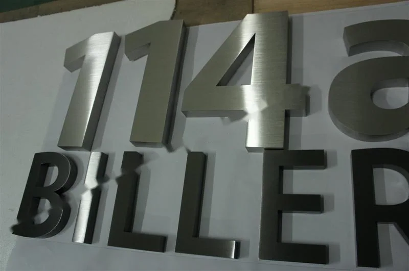 Metal sign letters on the workshop bench before finishing