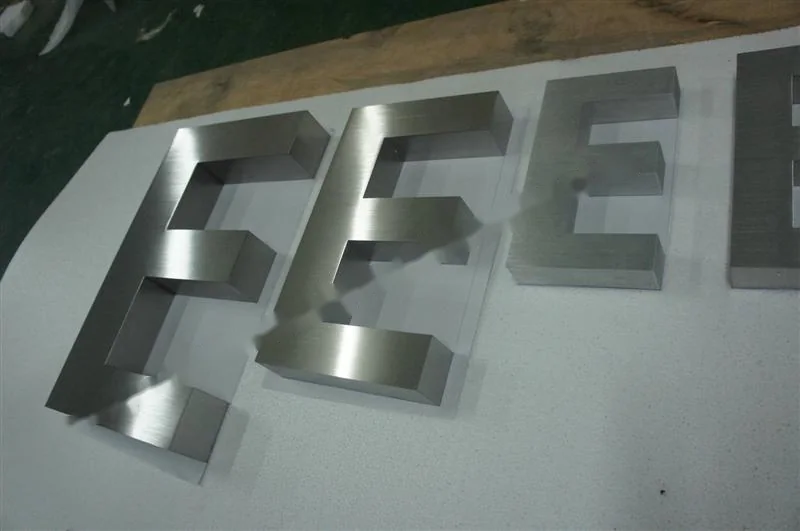 Metal sign letters on the workshop bench before finishing