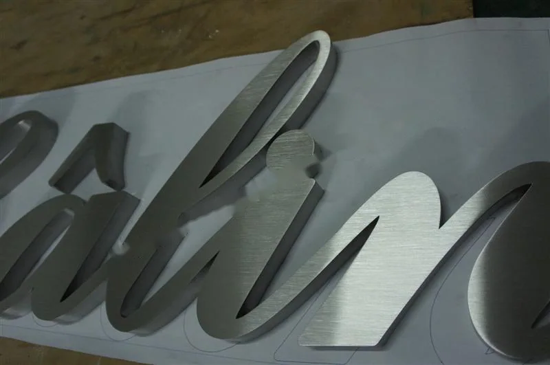 Metal sign letters on the workshop bench before finishing
