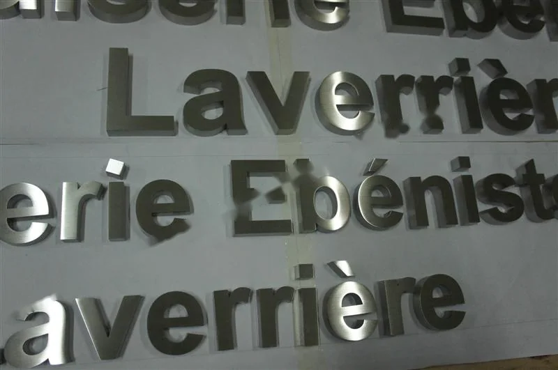 Metal sign letters on the workshop bench before finishing