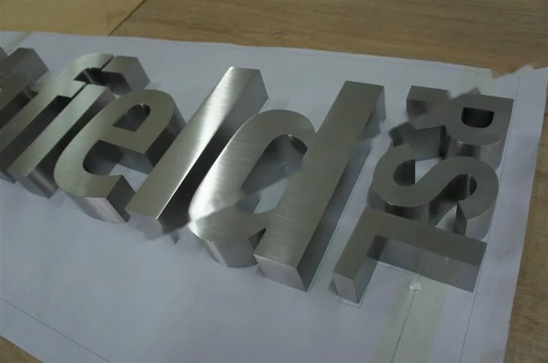 Metal sign letters on the workshop bench before finishing
