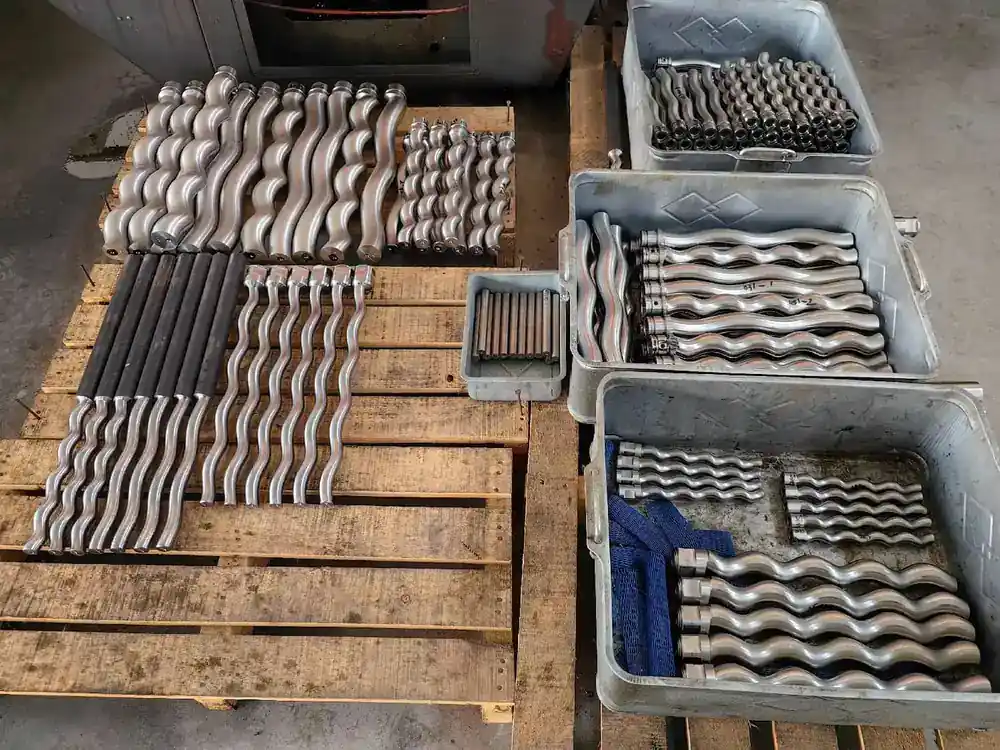 Batch of screw pump rotors laid out on pallets in the workshop