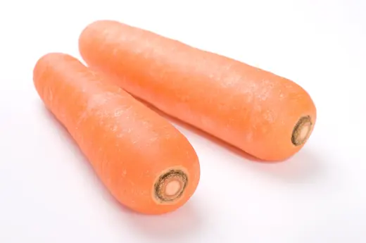 Two fresh orange carrots lying parallel on a clean white background