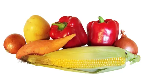 Assorted fresh vegetables: red bell peppers, corn on the cob, carrots, onion and potato on white background