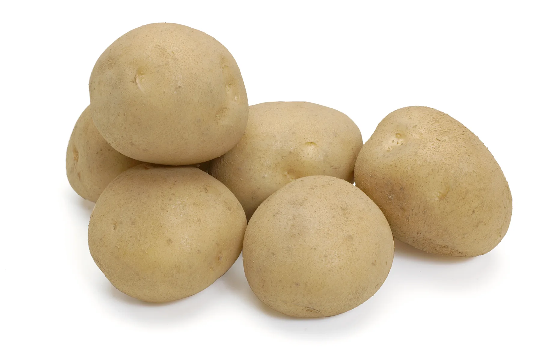Group of fresh yellow potatoes clustered on a plain white background