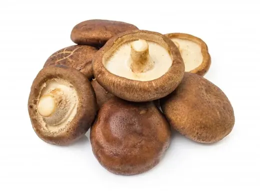 Whole and cut shiitake mushrooms packed in a glass jar