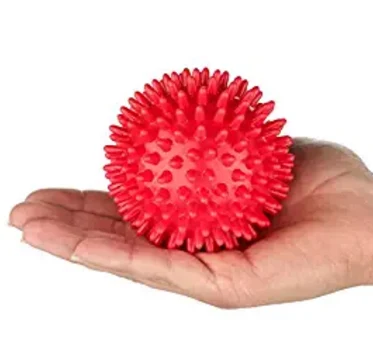Red spikey trigger point massage ball held in an open hand