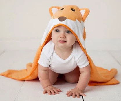 Yellow hooded terry baby towel worn by a child