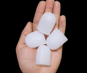 Two white silicone gel toe caps on a dark background