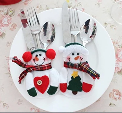 Felt snowman cutlery holders with stitched hats and scarves on a plate