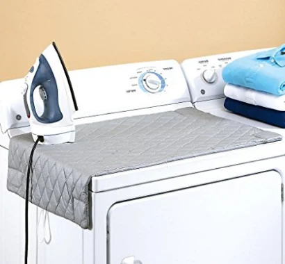 Ironing mat laid on a washing machine with an iron in use