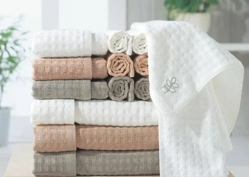 TW-354 waffle weave towels stacked in white beige grey and blush with an embroidered white towel