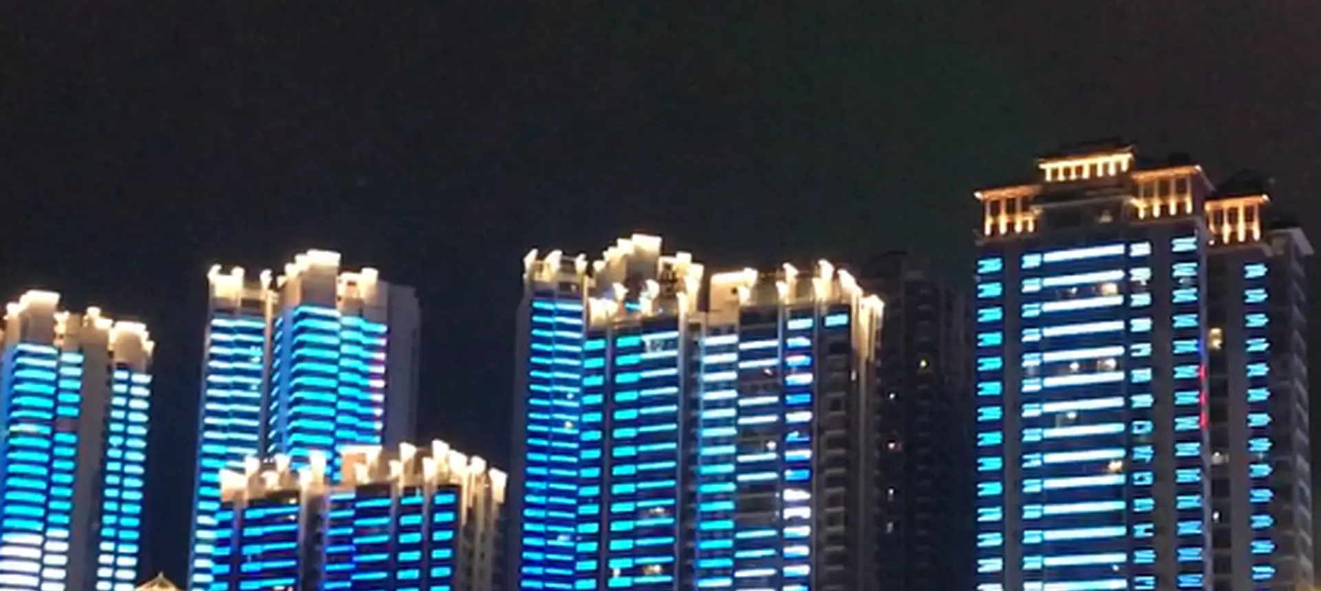 Twin residential towers running a blue full colour media facade built with FL Technology pixel lights