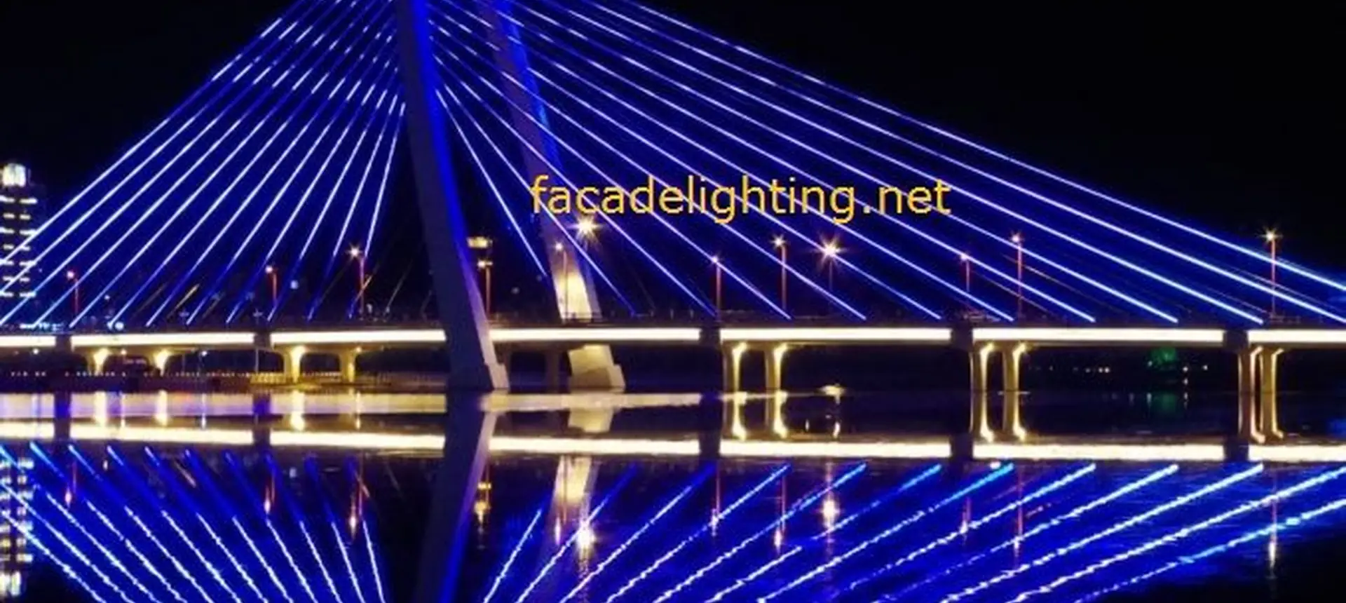 Cable stayed bridge lit with synchronised blue LED pixel light rays over the river