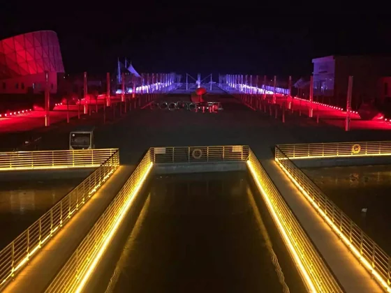 Road underpass approach lit with warm linear light lines and red accent lighting