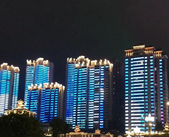 Twin residential towers running blue full colour media facade content at night