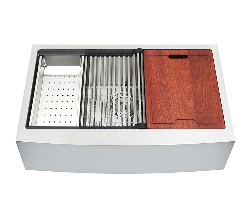 Single bowl apron sink shown with grid, colander and cutting board