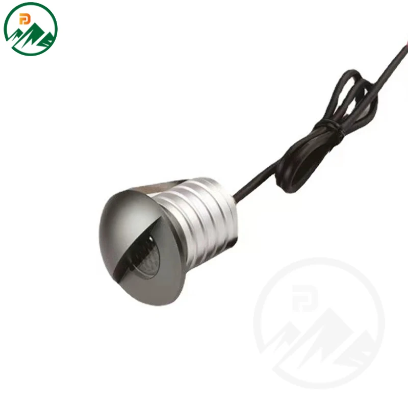 Recessed in-ground LED luminaire installed in paving with half-mask facing forward