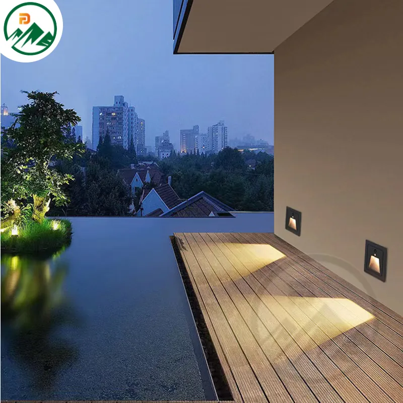 Underground corner light with white finish integrated into a paved courtyard