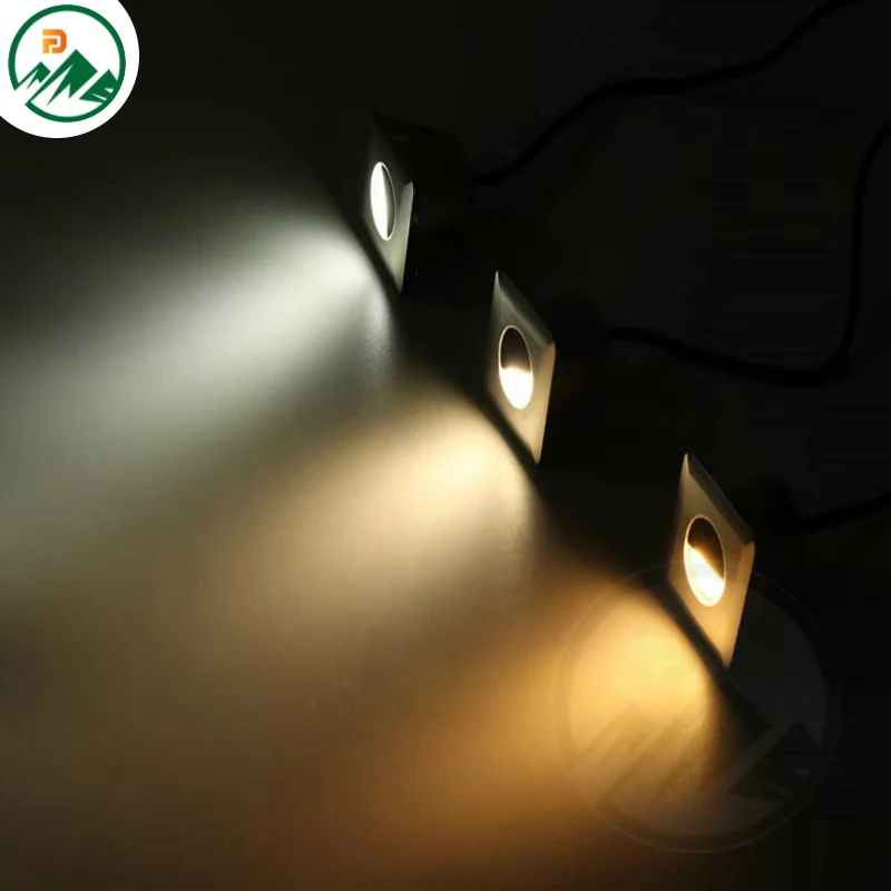 Fixture installed in a paved courtyard marking a pathway edge at night