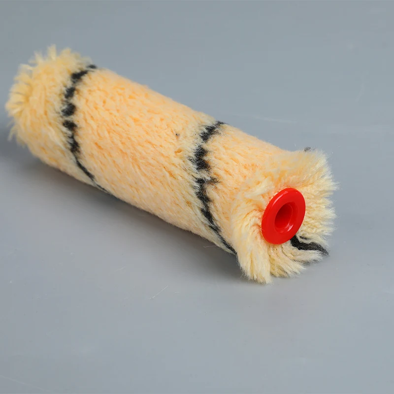 Yellow striped paint roller cover with fluffy fabric and red plastic end cap on gray background
