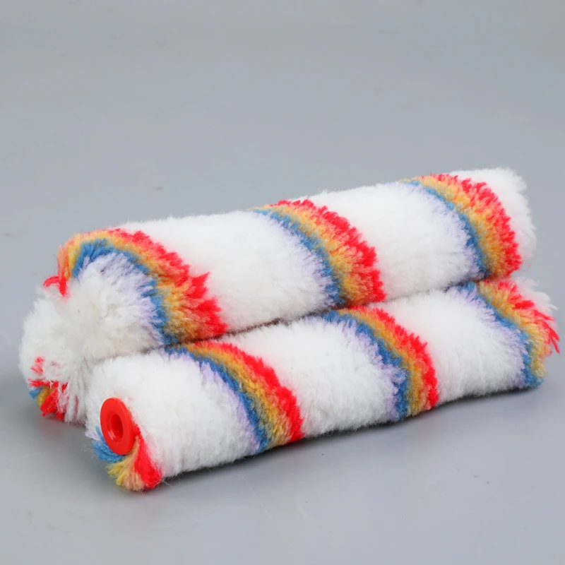 Two white striped paint roller covers stacked on a plain gray surface, one with a red plastic end cap