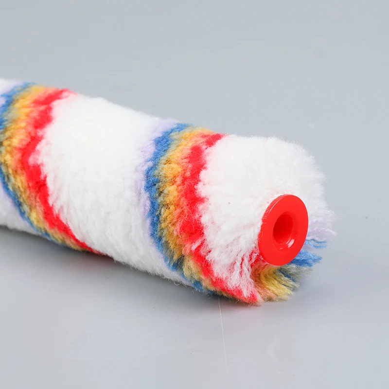 Striped fabric paint roller cover with red plastic end cap lying on a plain light background