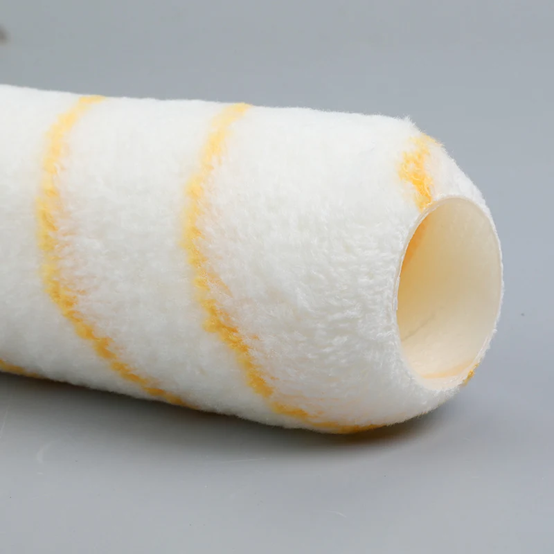 White paint roller cover with yellow spiral stripes lying on a plain gray background