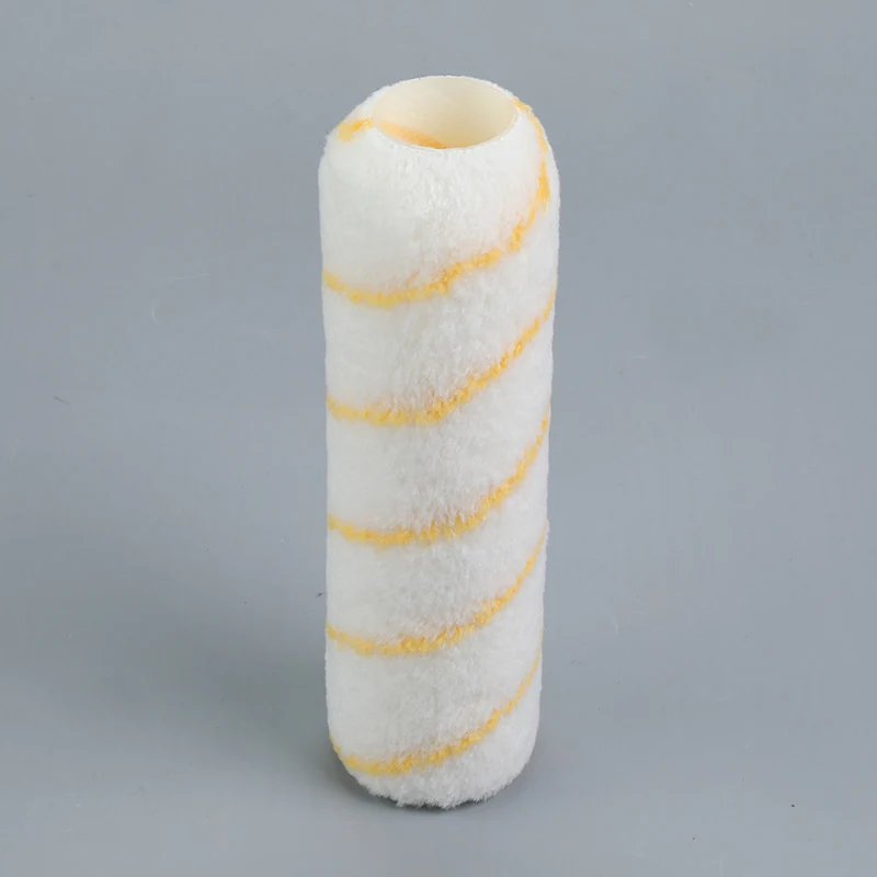 White fabric paint roller cover with yellow spiral stripes standing upright on a plain gray background