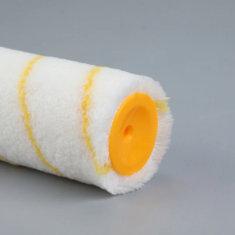 Close-up of a white and yellow striped paint roller cover with orange plastic end cap on gray background