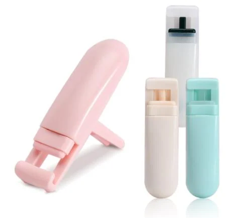 Portable eyelash curler tool with silicone tip in use on lashes