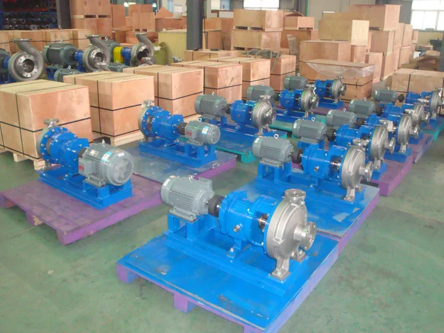 Rows of assembled centrifugal pump sets staged on pallets next to export crates