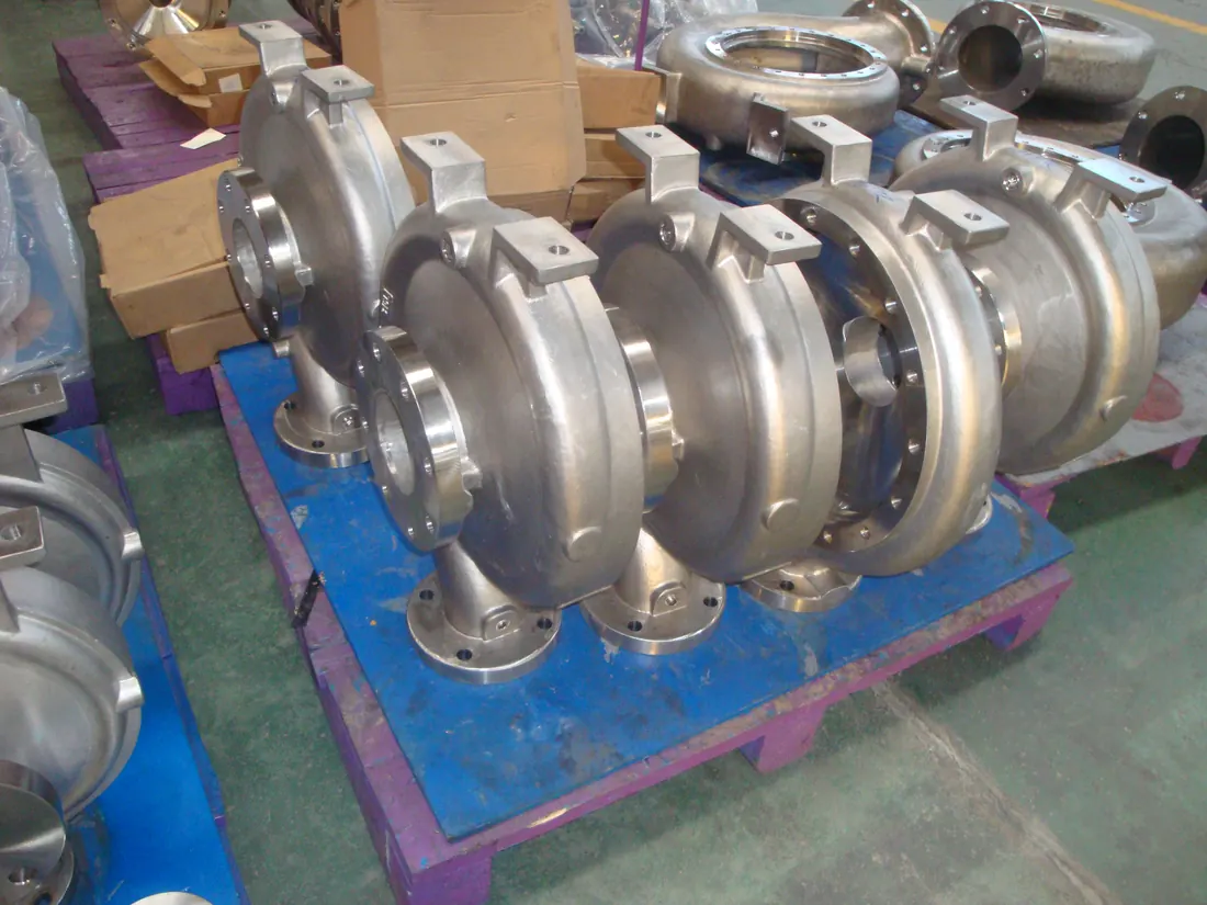 Stainless steel centrifugal pump volute casings staged on a pallet after casting and machining