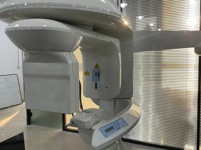 Carestream CS 9300 Select CBCT unit full front view — complete C-arm rotating gantry, patient positioner with black grip handles, cephalostat arm extending to the right, and CS Imaging operator console at the base, photographed on a blue pallet in our Shanghai warehouse