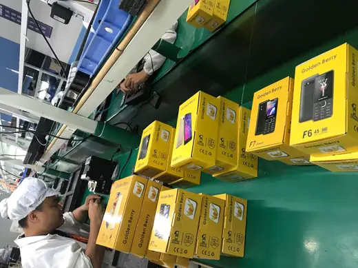 Boxed handsets being loaded from the line rack into shipping cartons.