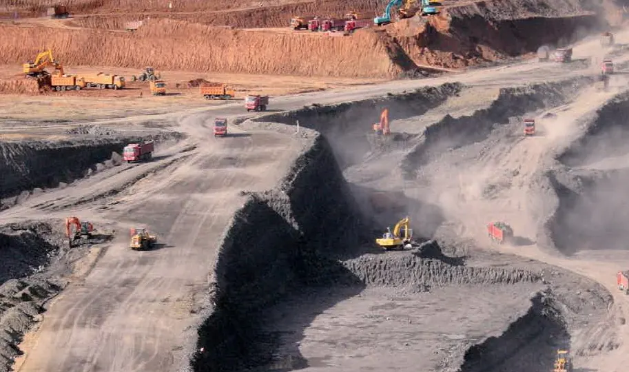 Excavators and haul trucks working a quarry bench