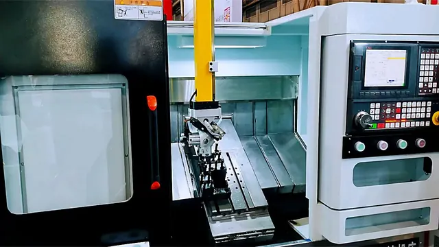 CNC machining centre with the work area lit through the open door