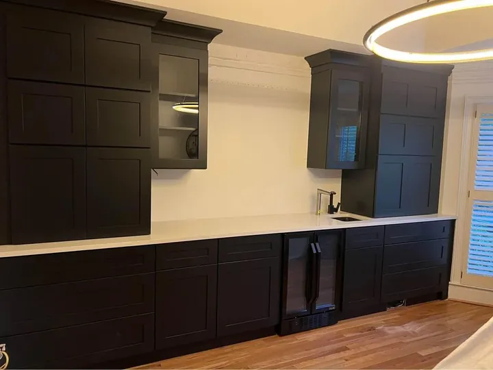 Dark painted shaker kitchen run with wall cabinets and a pale worktop