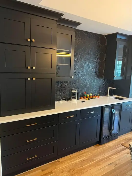 Shaker kitchen cabinets installed against a dark splashback