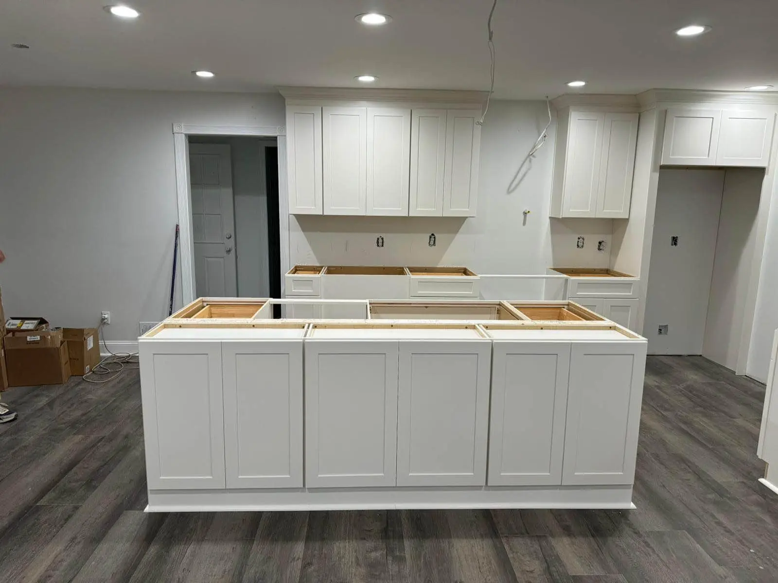 White painted shaker kitchen with a large island and timber worktop under installation