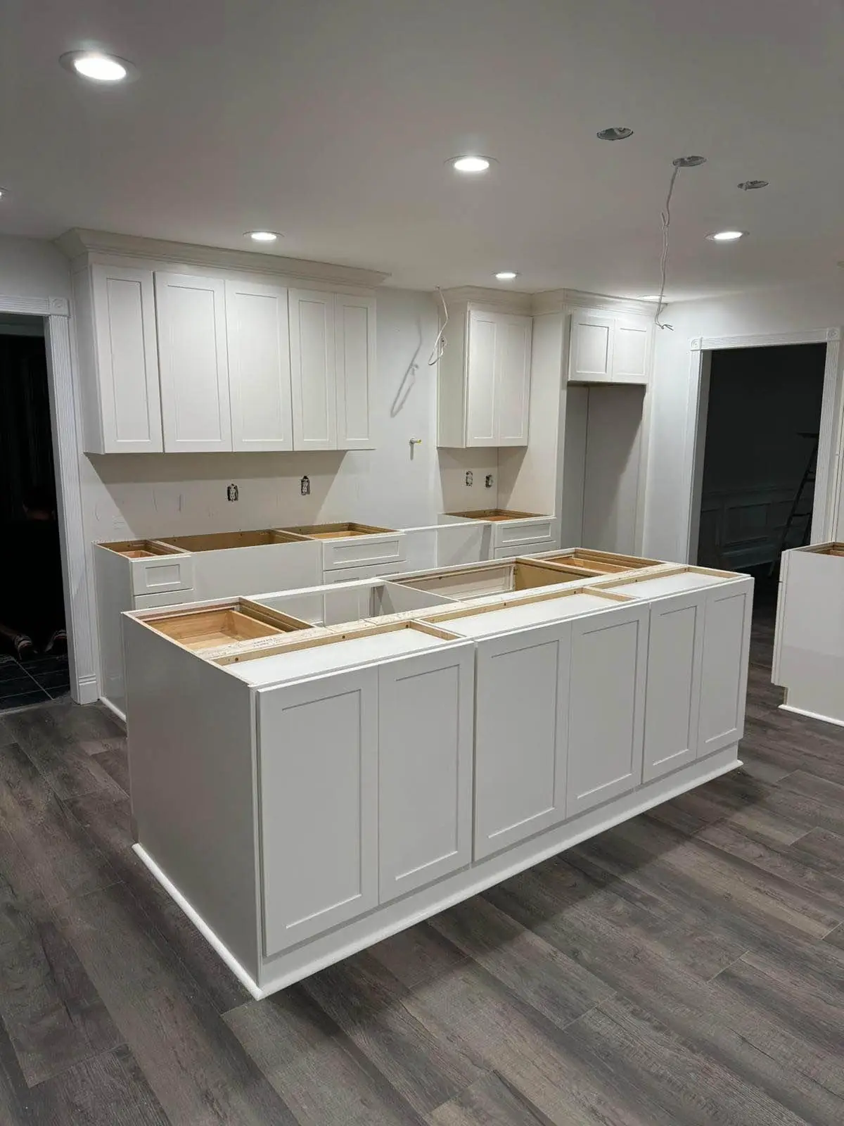 White shaker kitchen cabinets and island during installation