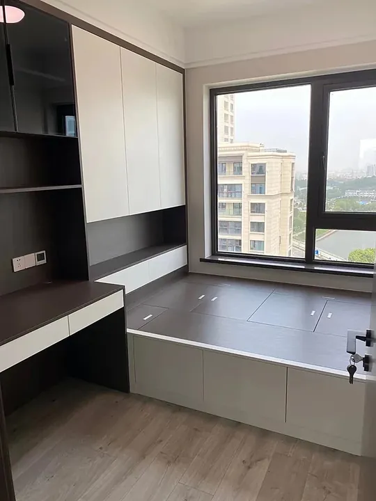 Fitted bedroom wardrobe carried around a bay window with a seat and desk