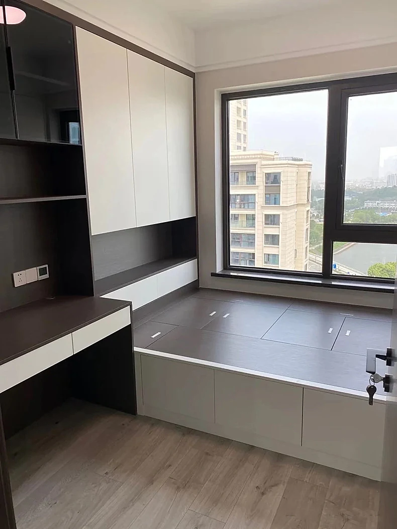Fitted bedroom wardrobe carried around a bay window with a seat and desk