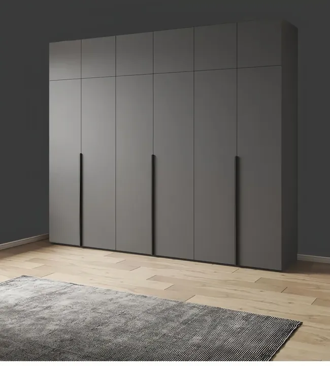Long dark grey flat panel wardrobe run with recessed vertical handles