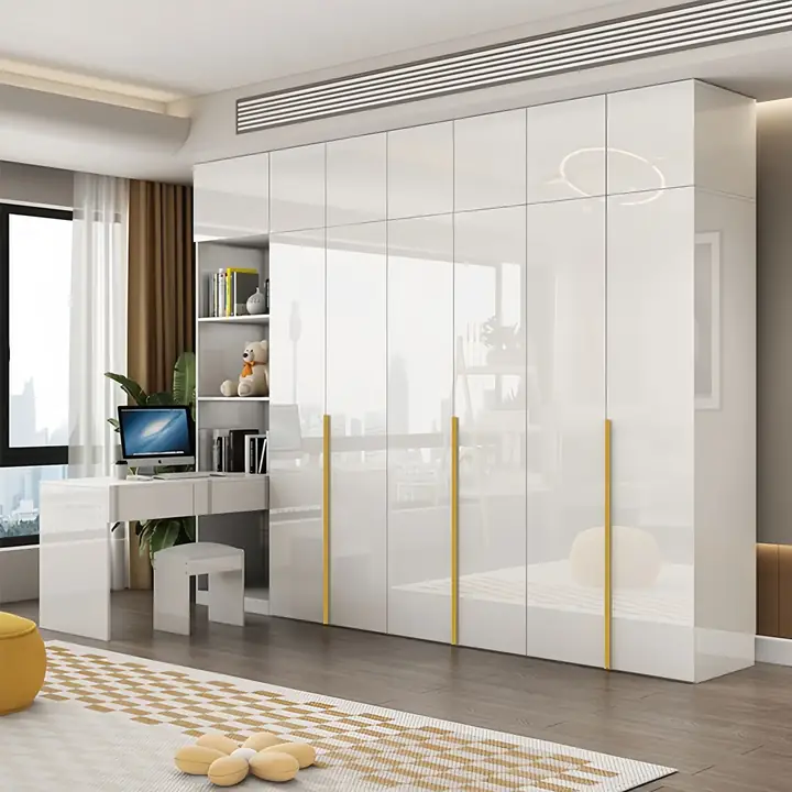 High gloss cream wardrobe run with gold vertical inlays beside an integrated desk and stool