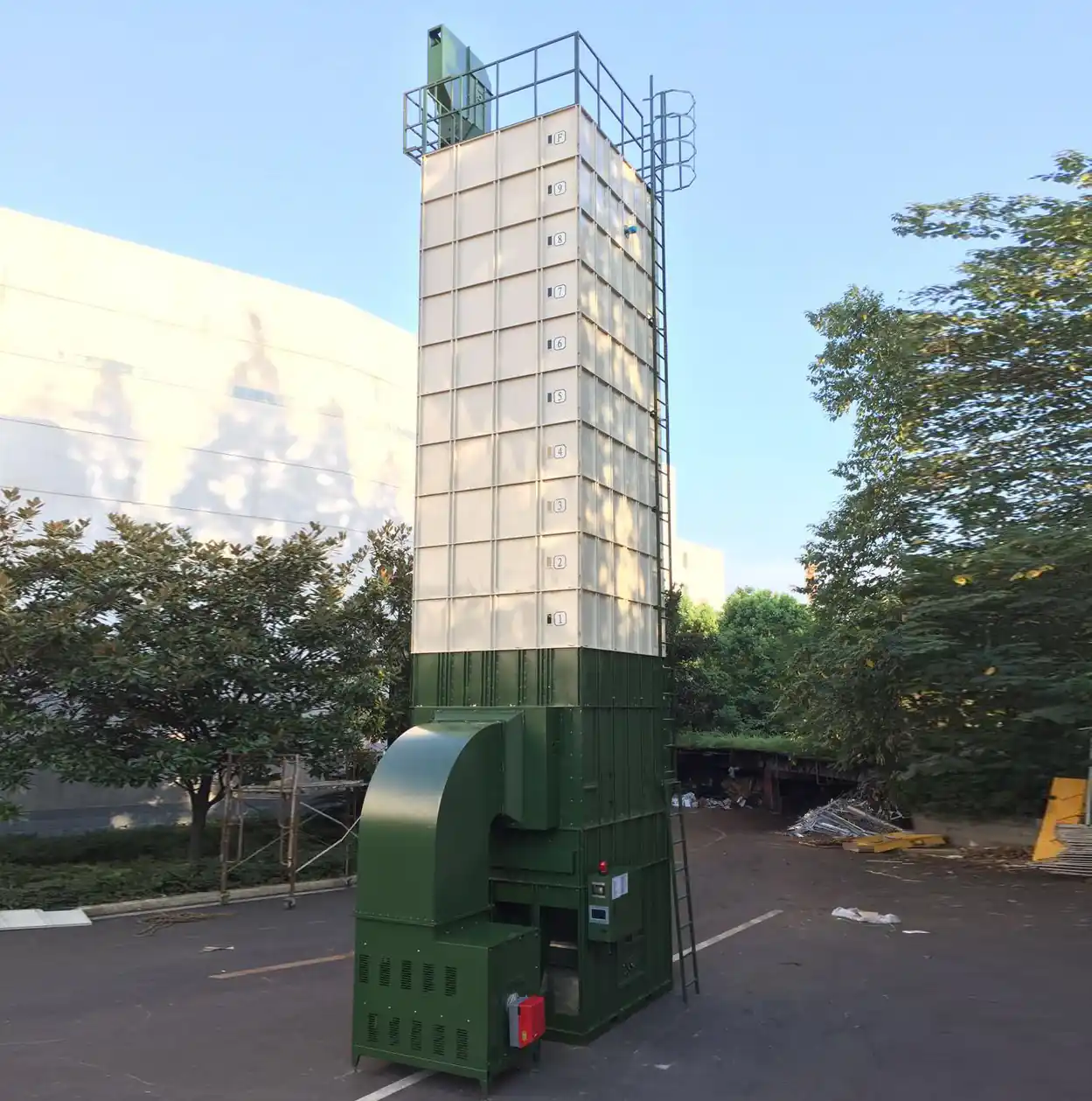 TITAN batch circulating grain dryer tower installed outdoors next to a plant building