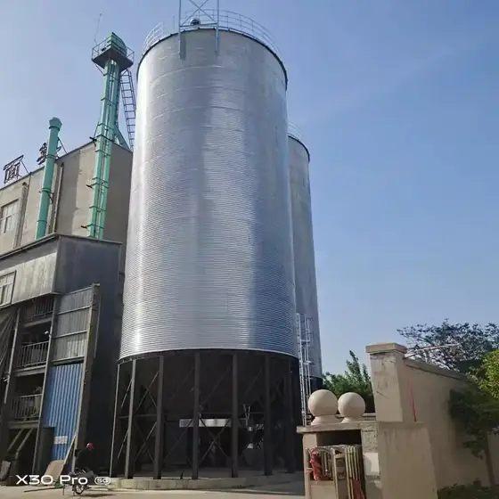 Galvanized wheat storage silos standing next to a flour mill building